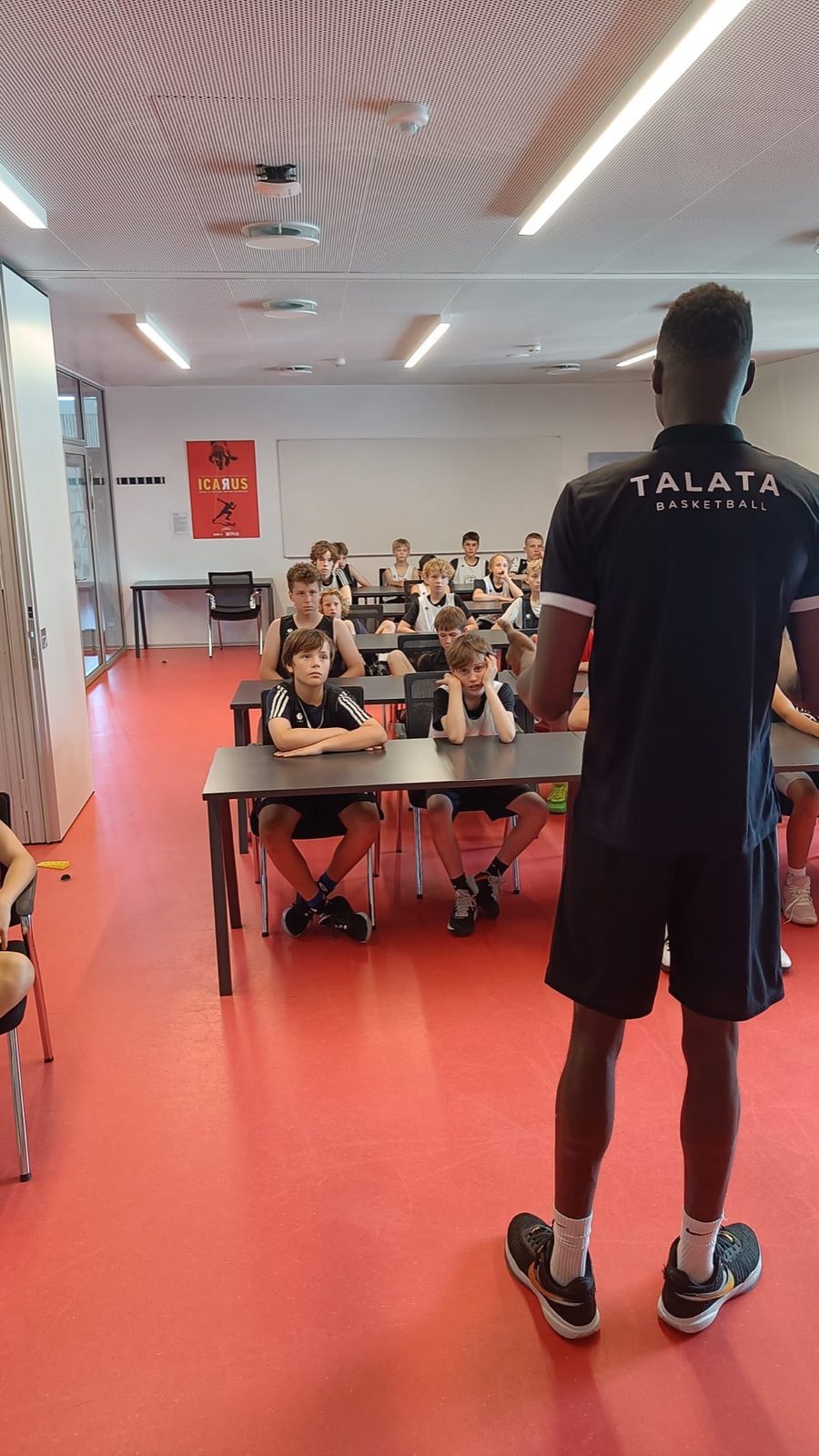 Talata coach leading a film session with camp players