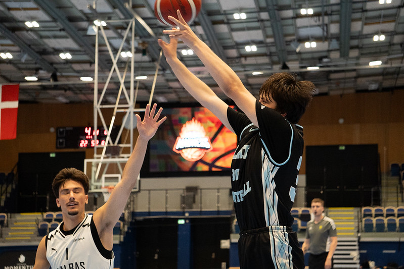 A Talata player rising into a contested shot under the Danish flag