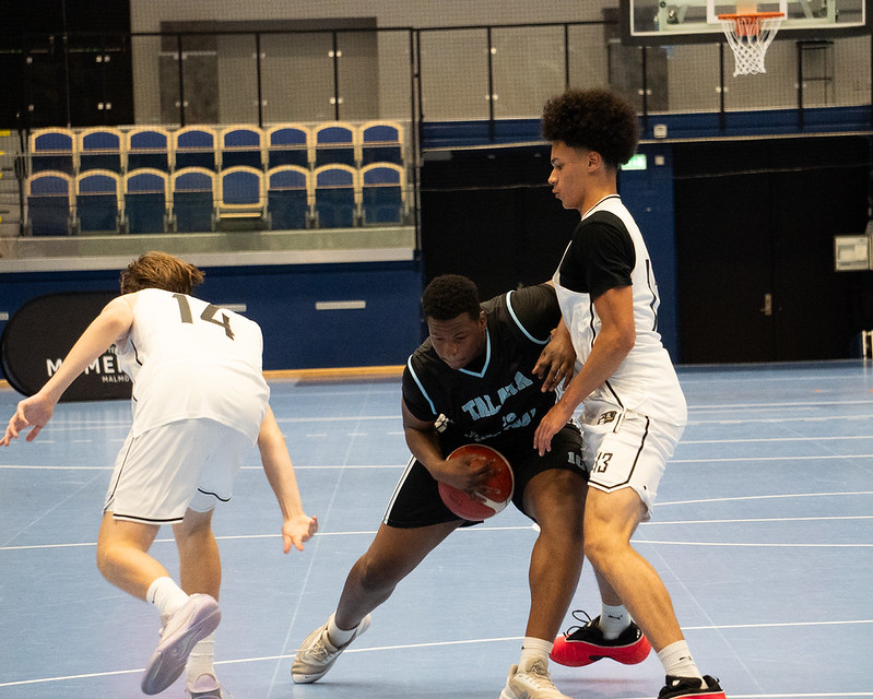A Talata player driving through contact between two defenders