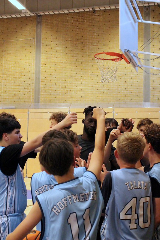 Talata players putting their hands in for a huddle under the basket