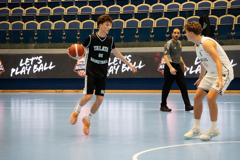 A Talata player bringing the ball up past the Let&rsquo;s Play Ball boards